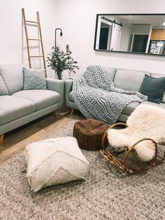 a living room filled with furniture and a mirror on the wall above it's headboard