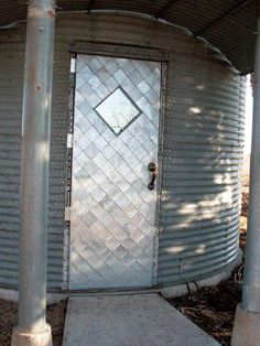 a metal building with a door and some poles