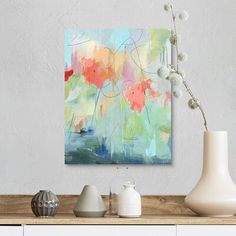 an abstract painting on a wall above a table with vases and other decor items