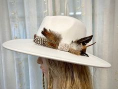 #14 in Rodeochics custom Hats White 2x wool hat is beautiful adorned with new Cowhide Hatband Hatband fabric is faux hide. A beautiful grouping of wild feathers accent the side Hook n loop closure Hat has a drawstring for making a smaller fit if needed Western Ranch Hats With Feathers, Custom Flat Brim Hat With Feathers, Hats With Feathers, Ranch Hats, Brimmed Hat Bands With Feather Trim For Western-themed Events, Western-themed Fedora With Feathers, Western-themed Fedora With Feather Trim, Hat Feathers, Custom Cowboy Hats