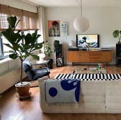 a living room filled with furniture and a flat screen tv on top of a hard wood floor