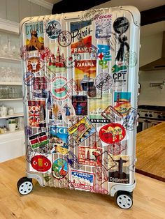 a piece of luggage covered in stickers on top of a wooden table next to an oven