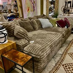 a large couch sitting on top of a floor next to a table with a vase