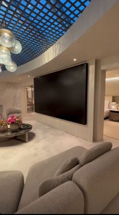 a living room filled with furniture and a flat screen tv mounted to the wall above it