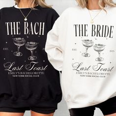 two women wearing matching sweatshirts that say the bride and last toast, with drinks on them