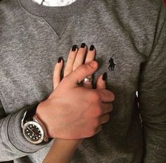 a person with black nails and a watch on their wrist