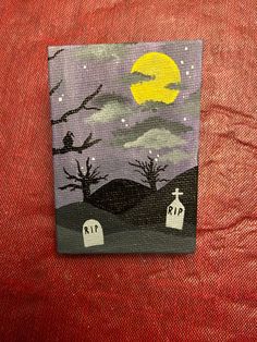 a painting on a piece of cloth with a cat sitting in the cemetery at night