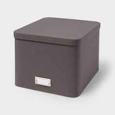 a gray box with a metal handle on the top and bottom, sitting against a white background