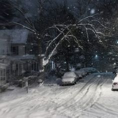 a snow covered street with cars parked on it