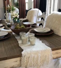 a wooden table topped with plates and glasses