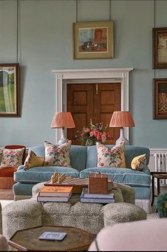 a living room filled with furniture and pictures on the wall