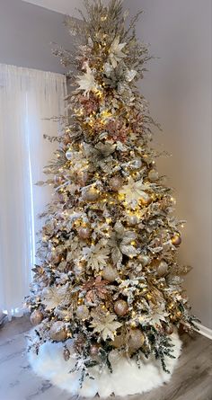 a white christmas tree with gold and silver decorations