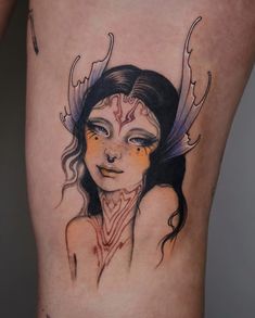 a woman's leg with an artistic tattoo design on the side and her face