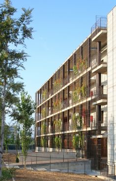 an apartment building with many balconies and plants growing on the side of it