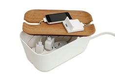 an iphone charging in a white box with wood and usb plugs attached to it