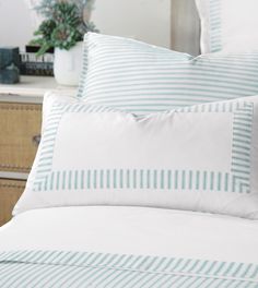 a bed with blue and white striped pillows