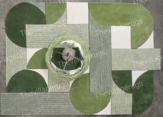 a green and white area rug with an animal in it's center surrounded by circles