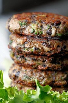 three patties stacked on top of each other with lettuce in the middle