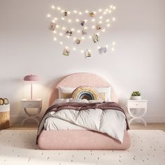 a bedroom with a pink bed and string lights on the wall above it, along with two nightstands