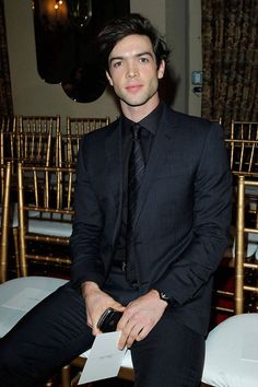 a man in a suit and tie sitting on a chair