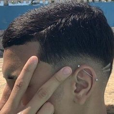 a close up of a person touching their ear