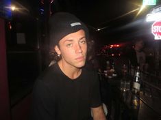 a young man sitting at a table in front of a stop sign and some drinks