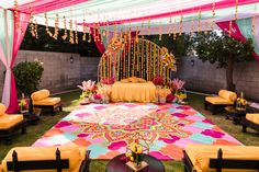 Pithi/Haldi decor with colorful draping and bright dance floor Haldi Dance Floor Flex Design, Sangeet Floor Decor, Mehndi Dance Floor Decor, Colorful Haldi Decor, Backyard Haldi Decor, Haldi Dance Floor, Carnival Haldi Decor, Ladies Sangeet Decoration, Haldi Carnival Decor