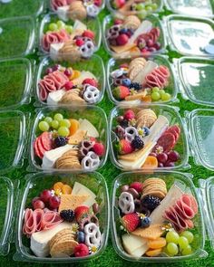 several plastic containers filled with different types of food on top of a green table covered in grass