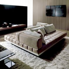 a living room filled with furniture and a flat screen tv on top of a wall