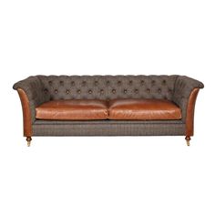 a brown leather couch sitting on top of a white floor next to a wooden frame