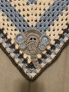 a crocheted blue and white square with an elephant on it's side