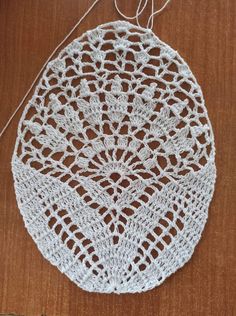 a white crocheted doily hanging from a string