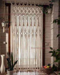 a window curtain with tassels hanging from it's sides and a potted plant on the other side