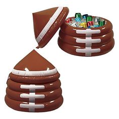 an inflatable football shaped container with candy sticks and markers on the top is shown