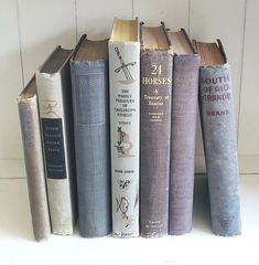 a row of books sitting on top of a white shelf