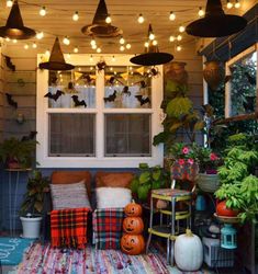 a porch decorated for halloween with pumpkins and lights