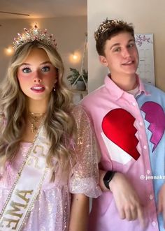 two people in costumes standing next to each other and one is wearing a heart shaped shirt