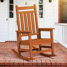 a wooden rocking chair sitting on top of a red brick porch next to a white door