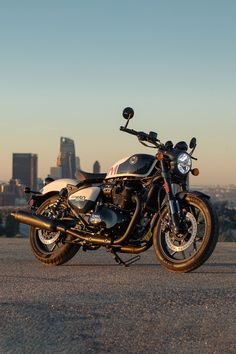 a motorcycle parked in front of a cityscape with the sun shining on it