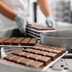 chocolate bars are being made in the kitchen by a baker's gloved hand