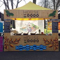 an outdoor food stand with various foods on it's sides and signage for the house of dodo