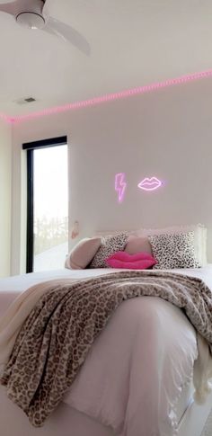 a bedroom with white walls and pink lights on the ceiling is decorated in leopard print