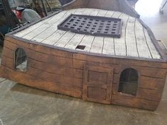 a boat made out of wooden planks and metal grates on the bottom floor