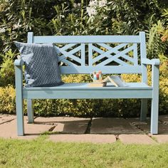 a blue bench sitting in front of some bushes