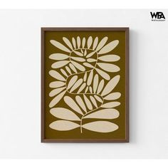 a brown and white wall hanging on the side of a wall next to a plant