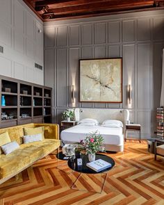 a living room filled with furniture and a large painting on the wall above it's headboard