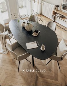 a table with chairs and a vase on it in the middle of a living room