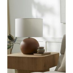 a table with a lamp on top of it and a book sitting next to it