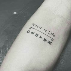 a person with a tattoo on their arm that reads music is life and arrows are in the background