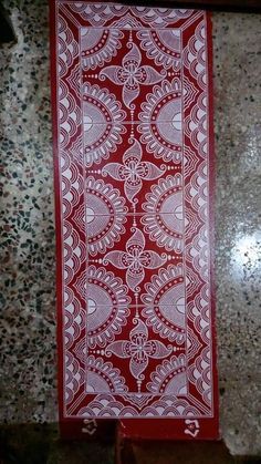 a red and white table cloth sitting on top of a marble counter next to a tile floor